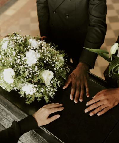 Mourners touching coffin at funeral
